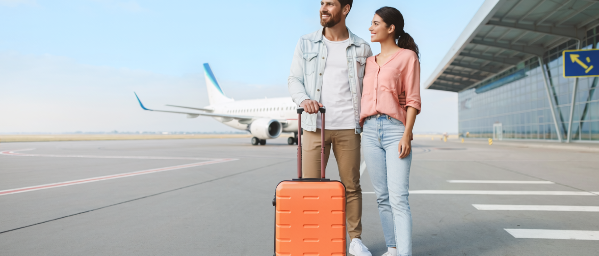 Pareja con maleta en aeropuerto, lista para viajar con seguros de viaje IMA Iberica.